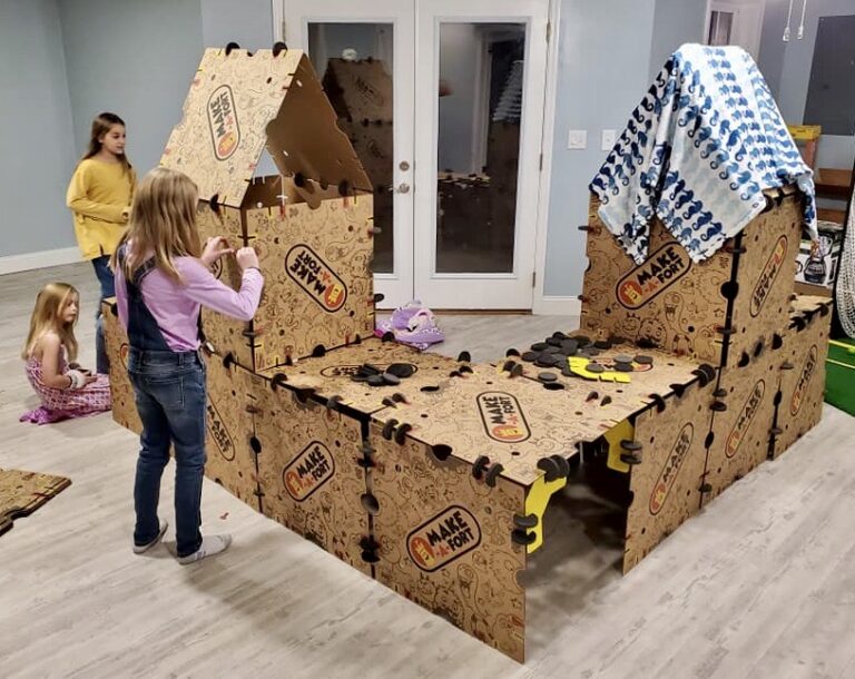 3 girls building fort w blanket on gable