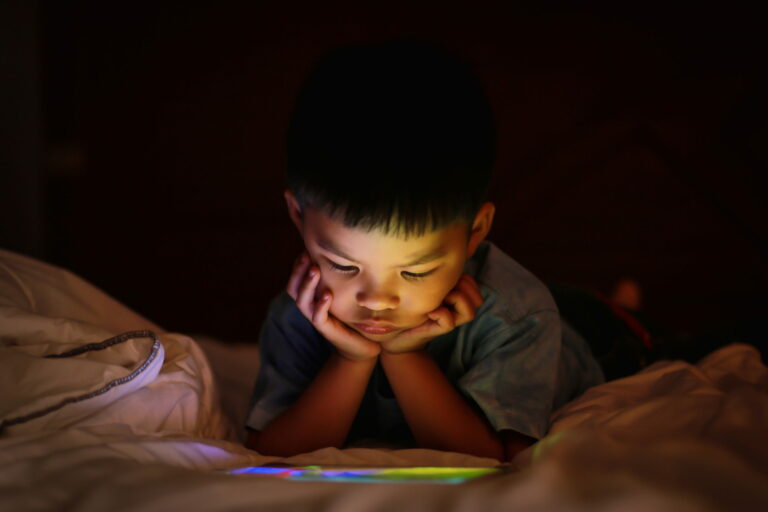 Joven mirando un iPad por la noche